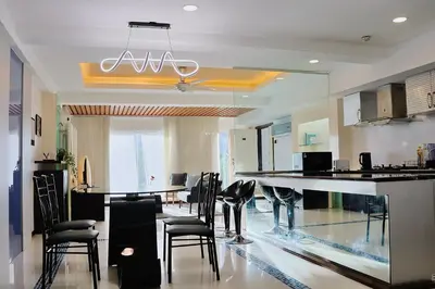 a kitchen with a bar with black chairs in it at 3BR at Holiday Place Kuala Lumpur 5 mins to KLCC & MRT in Kuala Lumpur