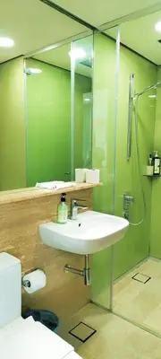 a bathroom with a sink and a shower and a mirror at Sky Suites KLCC by TD Luxury Homestay in Kuala Lumpur
