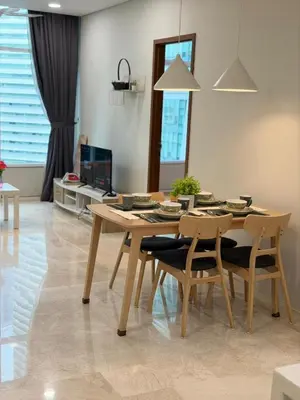 a dining table and chairs in a living room at Sky Suites KLCC by TD Luxury Homestay in Kuala Lumpur