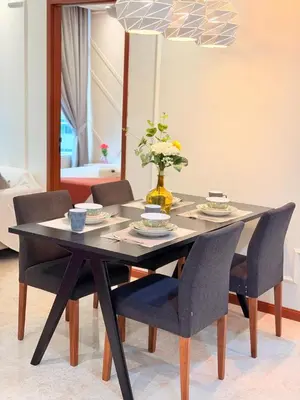 a black dining room table with chairs and a vase with flowers at Sky Suites KLCC by TD Luxury Homestay in Kuala Lumpur