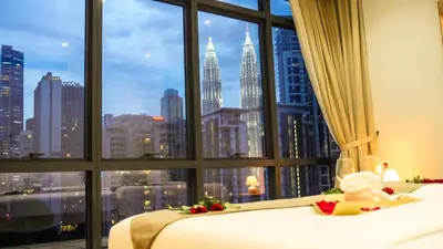 a bedroom with a window with a view of the city at Manor Residences KLCC in Kuala Lumpur