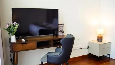 a desk with a chair and a television in a room at Manor Residences KLCC in Kuala Lumpur