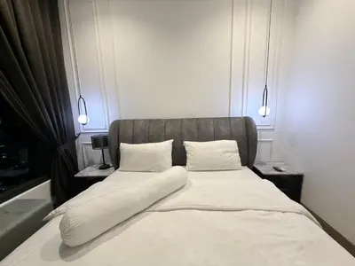 a bed with white sheets and pillows in a room at Lucentia Residence Bukit Bintang LalaportBBCC By VELLORA in Kuala Lumpur