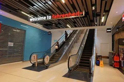 an escalator in a store with a person walking down it at Fahrenheit88 Suites Bukit Bintang B 2R in Kuala Lumpur