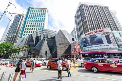 a busy city street with cars parked in front of tall buildings at Fahrenheit88 Suites Bukit Bintang B 2R in Kuala Lumpur