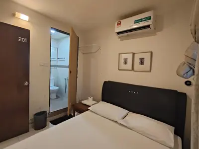 a bedroom with a white bed and a bathroom at HOTEL NoVA in Kuala Lumpur