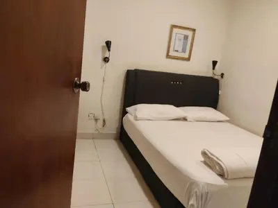 a small bedroom with a bed with white sheets at HOTEL NoVA in Kuala Lumpur
