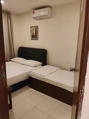 two beds in a small room with a heater at HOTEL NoVA in Kuala Lumpur