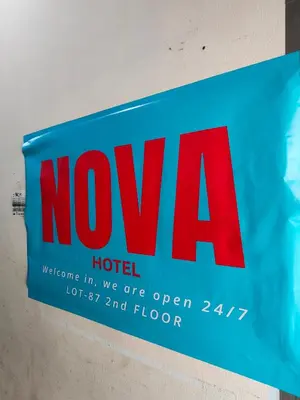 a blue and red hotel sign hanging on a wall at HOTEL NoVA in Kuala Lumpur