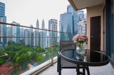a glass table with a vase of flowers on a balcony at KLCC View Suites with balcony at The Manor Residence in Kuala Lumpur