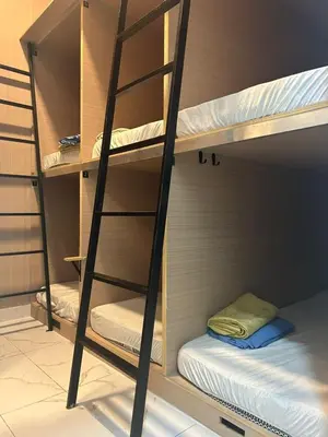 two bunk beds in a room with a ladder at KING HOSTEL by Global Inn in Kuala Lumpur