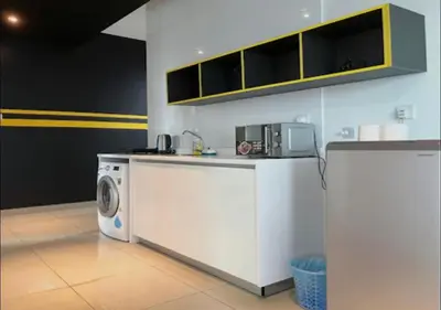 a kitchen with a washing machine and a microwave at Affordable at Arte Plus near KLCC with WiFi and Parking in Kuala Lumpur