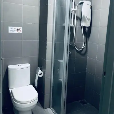 a bathroom with a shower with a toilet and a glass shower stall at Summer Suites KLCC by Vho'Z in Kuala Lumpur