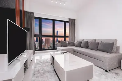 a living room with a couch and a tv at Agile Bukit Bintang, 54th Floor Apt, Infinity Pool in Kuala Lumpur