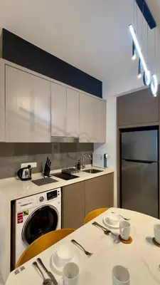 a kitchen with a table with chairs and a dishwasher at Agile Bukit Bintang, 54th Floor Apt, Infinity Pool in Kuala Lumpur
