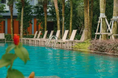 a group of lounge chairs next to a swimming pool at Agile Bukit Bintang, 54th Floor Apt, Infinity Pool in Kuala Lumpur