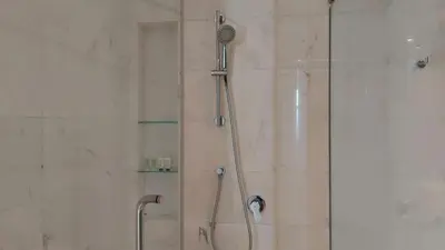 a shower with a glass door and a shower constructorangering at Aura Suites at Platinum KLCC in Kuala Lumpur