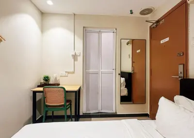 a bedroom with a bed and a desk with a chair at Swing & Pillows - Sentul Jalan Ipoh Kuala Lumpur in Kuala Lumpur