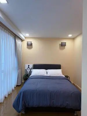 a bedroom with a large bed with a blue blanket at Prime location in Bukit Bintang, Studio for 2 in Kuala Lumpur
