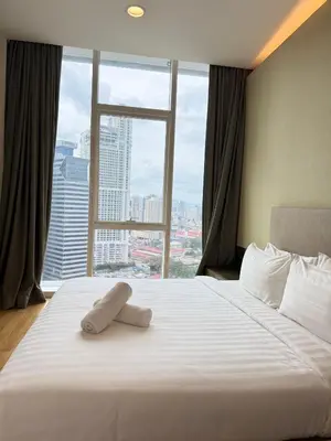 a bedroom with a large white bed with a large window at PLATINUM SUITES KLCC By CHENLUN in Kuala Lumpur