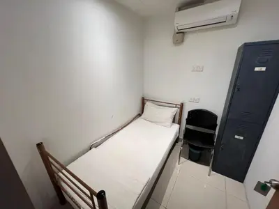 a small room with a small bed and a chair at BG Travelers Home in Kuala Lumpur