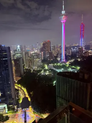 a city skyline with a tower lit up at night at Platinum Suites in Kualalumpur City Center in Kuala Lumpur