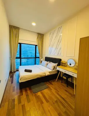 a bedroom with a bed and a desk and a window at Rosewood Suites at Reizz Residence in Kuala Lumpur