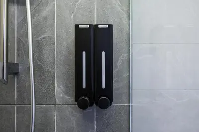 a couple of black objects on the wall of a shower at Majestic Residence KLCC Royal Premium King Bed in Kuala Lumpur