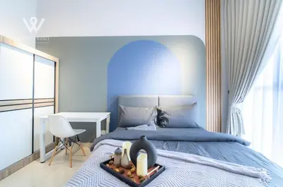 a blue bedroom with a bed with a candle on it at 2BR Minimalist Urban Retreat at Trion KL in Kuala Lumpur