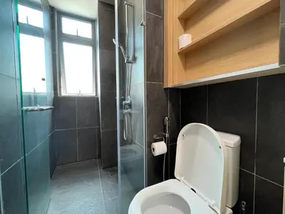 a bathroom with a toilet and a glass shower at The Colony By Infinitum By Paradgm Stay in Kuala Lumpur
