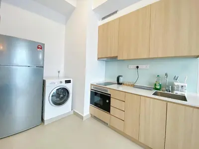 a kitchen with a refrigerator and a washing machine at The Colony Infinitum By Paradgm Nest Stay in Kuala Lumpur