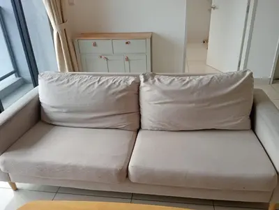 a couch with two pillows sitting in a room at Trion KL By Paradgm Nest Stay Free Parking in Kuala Lumpur