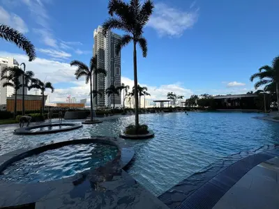 a pool of water with palm trees and a building at Trion KL By Paradgm Nest Stay Free Parking in Kuala Lumpur