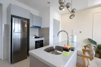 a kitchen with a sink and a stainless steel refrigerator at Trion KL By Paradgm Stay With Balcony in Kuala Lumpur