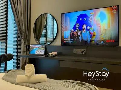 a bedroom with a tv on a shelf with a mirror at Isola KLCC by HeyStay Management in Kuala Lumpur