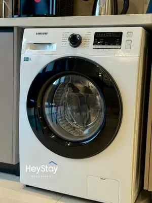 a white washing machine sitting in a kitchen at Isola KLCC by HeyStay Management in Kuala Lumpur
