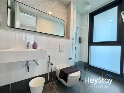 a bathroom with a toilet and a sink and a mirror at Isola KLCC by HeyStay Management in Kuala Lumpur