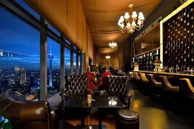 a bar with leather chairs and a view of a city at High-Floor Suasana KL Stay Cozy & Central in Kuala Lumpur