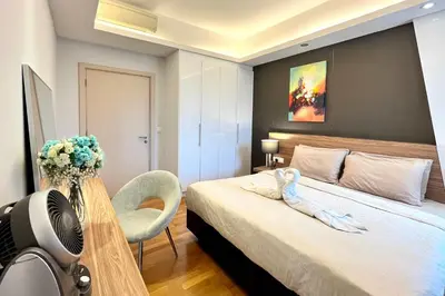 a hotel room with a bed with a fan and flowers at High-Floor Suasana KL Stay Cozy & Central in Kuala Lumpur