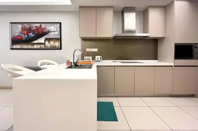 a kitchen with white countertops and a painting on the wall at High-Floor Suasana KL Stay Cozy & Central in Kuala Lumpur