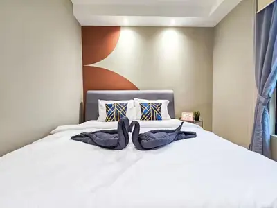 two swans laying on top of a white bed at Casa Residency Family CityView Suites by CityNest in Kuala Lumpur