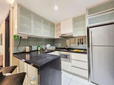 a kitchen with white cabinets and a black counter top at Casa Residency Family CityView Suites by CityNest in Kuala Lumpur