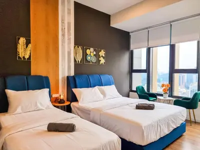 two beds in a hotel room with blue chairs at KL City Designer Studio in Ceylonz with KL118 Tower View CityNest in Kuala Lumpur