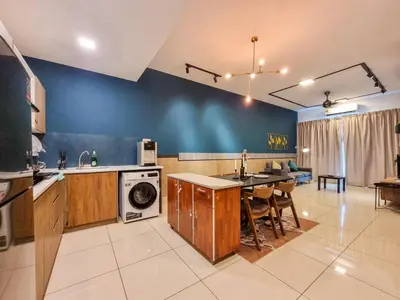 a kitchen with a washing machine and a dining room at One Residences Family Suites KL by CityNest in Kuala Lumpur