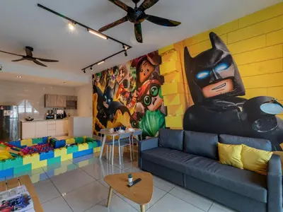 a living room with a batman mural on the wall at One Residences Family Suites KL by CityNest in Kuala Lumpur