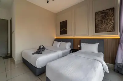 a hotel room with two beds with white sheets at One Residences Family Suites KL by CityNest in Kuala Lumpur