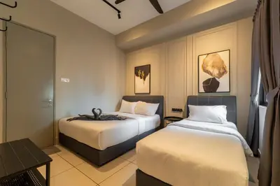 a hotel room with two beds and a table at One Residences Family Suites KL by CityNest in Kuala Lumpur