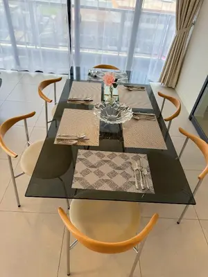 a dining room with a glass table and chairs at The Atrium Jalan Ampang Elegant Fully Air-Con 3 BR Homestay in Kuala Lumpur