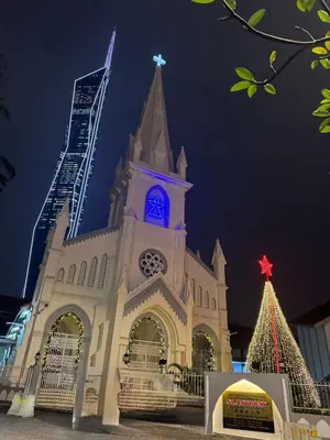 a church with a clock tower and a christmas tree at Robertson S23A KLCC Bukit Bintang Jalan Alor Petaling Street 2R 7Pax in Kuala Lumpur