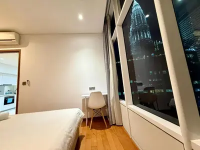a bedroom with a window with a view of a building at Apartment KL Luxury Home Stay in Kuala Lumpur